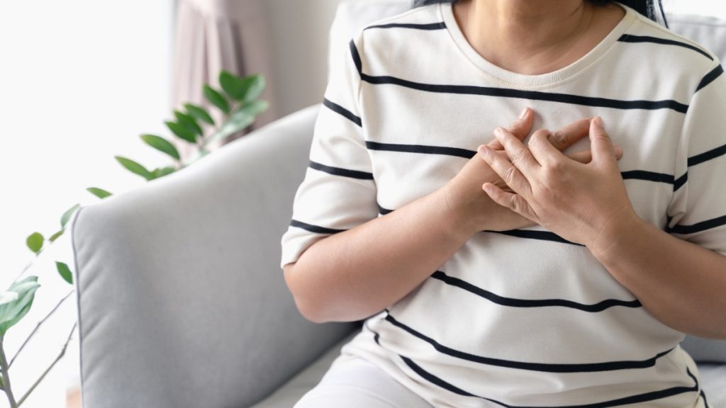 A woman's hands over her heart, symbolising emotional clutter and the internal barriers to decluttering