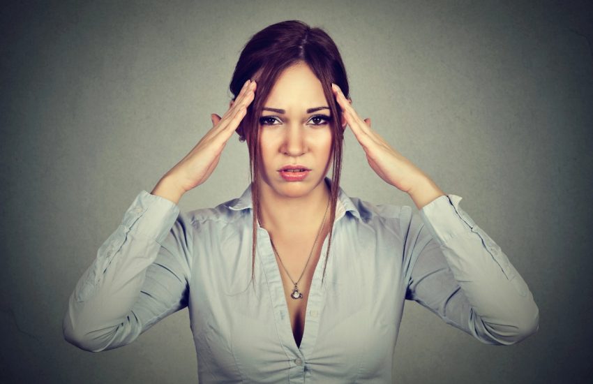Overwhelmed woman representing the mental exhaustion of decluttering your home and the "frozen" feeling of task paralysis