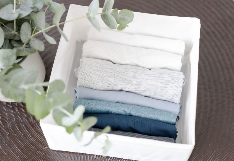 Organised clothes in a small bin representing manageable decluttering wins